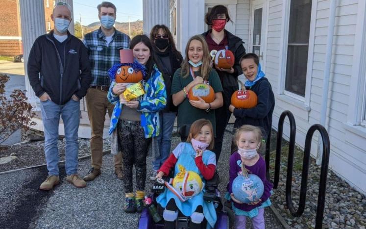 Pumpkin decorating contest winners posing with White Mountain Rotary Club members. 